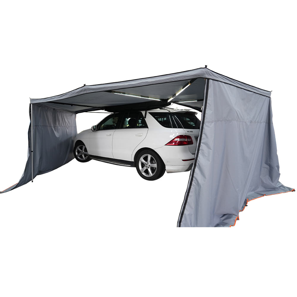 Toldo para vehículo instalado junto a un vehículo de camping en coche
